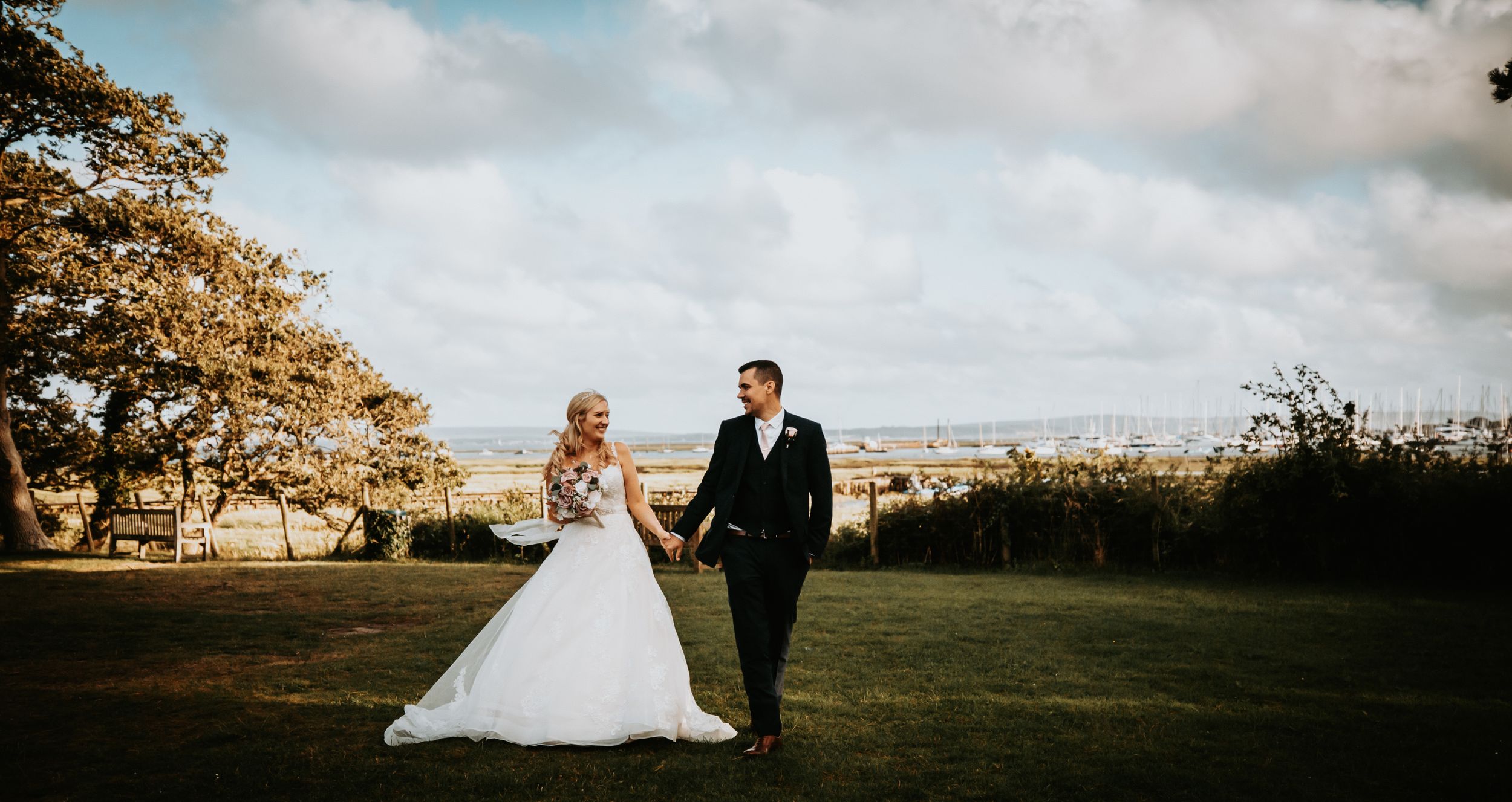 Scenic outdoor wedding photos with rolling hills and dramatic sky at sunset.