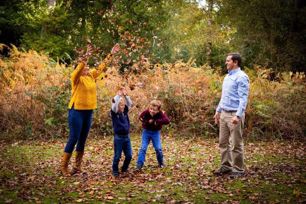 Autumn family photo session in a forest with colorful fall foliage.