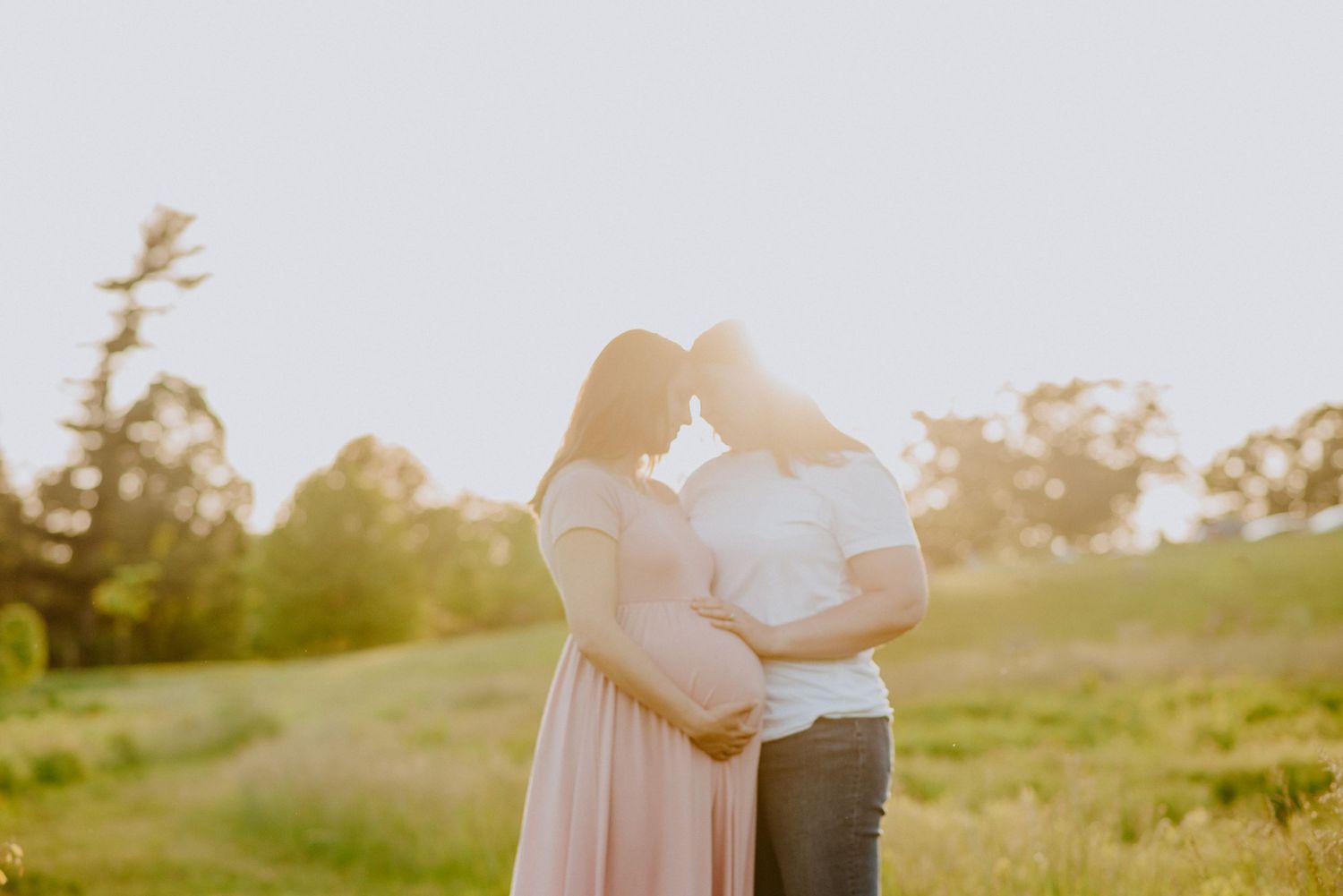 Candid moment between two moms to be during golden hour