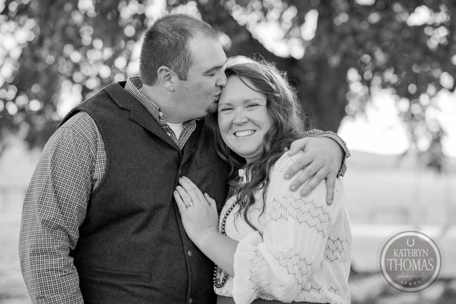 Black and white intimate portrait of couple embracing outdoors.