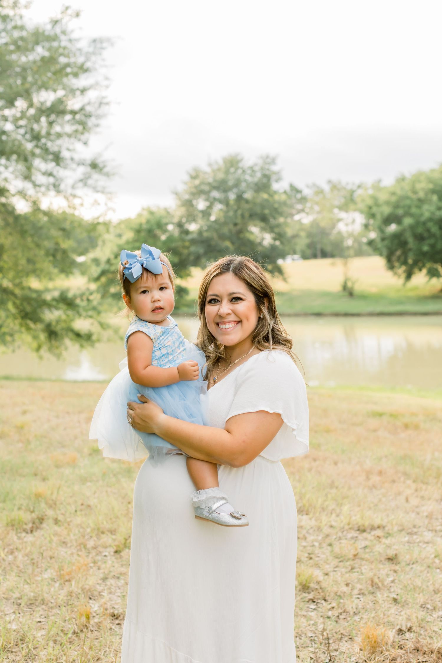 A sweet moment captured between parent and child wearing matching blue accents in a natural setting.
