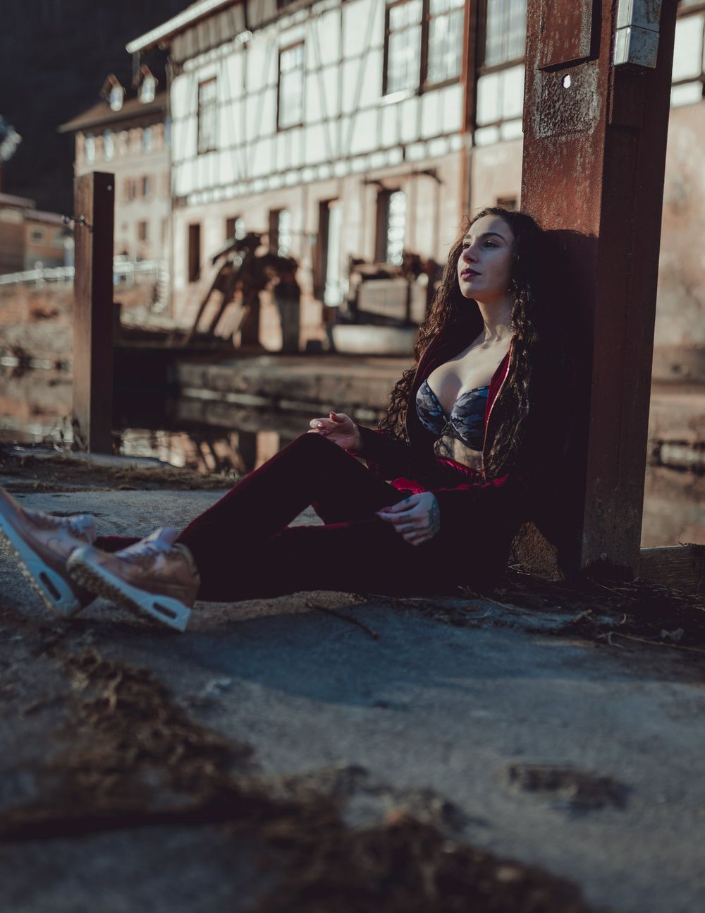Atmospheric evening portrait against historic architecture with dramatic lighting.