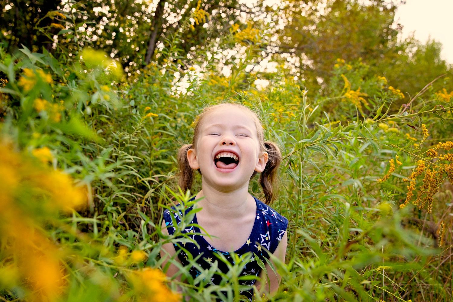 Pure joy radiates through a garden filled with lush greenery and golden sunlight in this heartwarming outdoor scene.