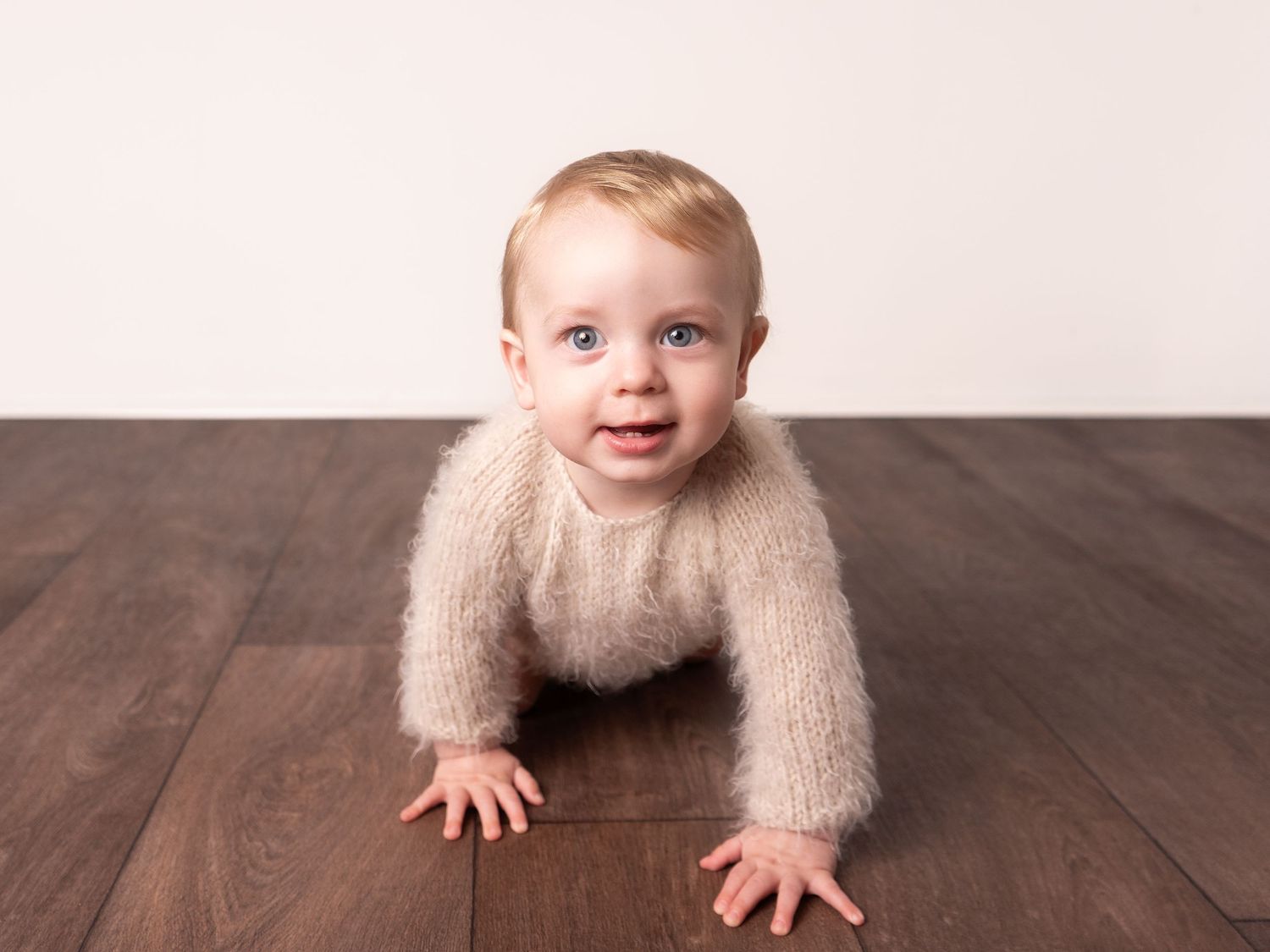 6 months old sitter session baby boy crawling in fluffy romper by photographer in Doncaster.