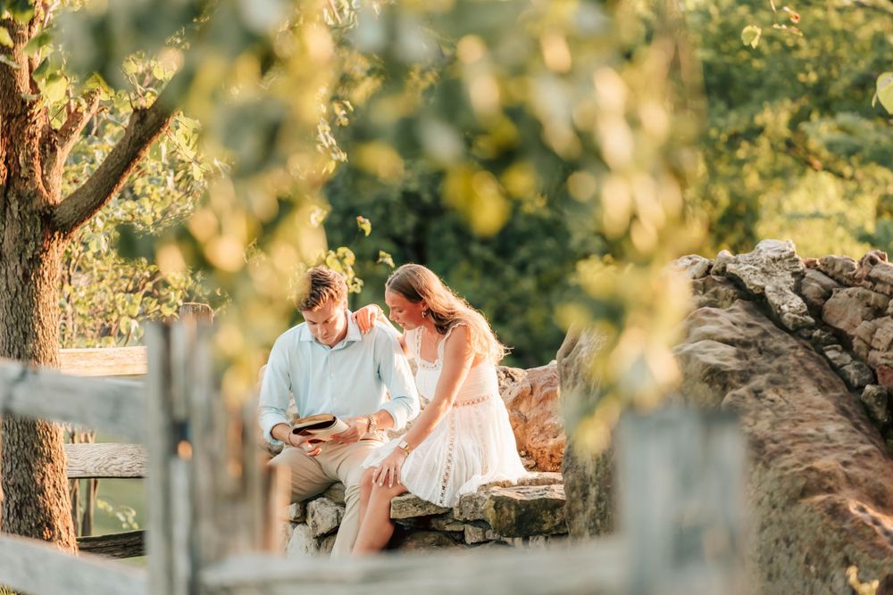 A romantic couple enjoys a sunset moment together in a vineyard setting.