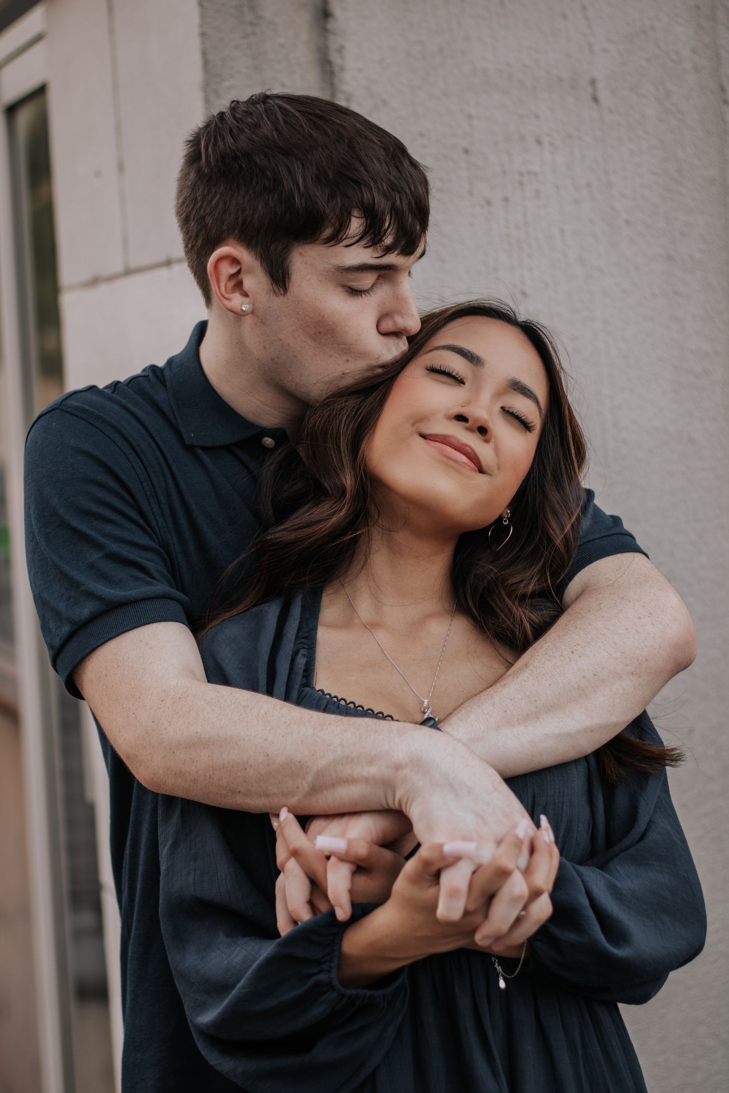 Intimate couple portraits against white wall showing tender embraces.