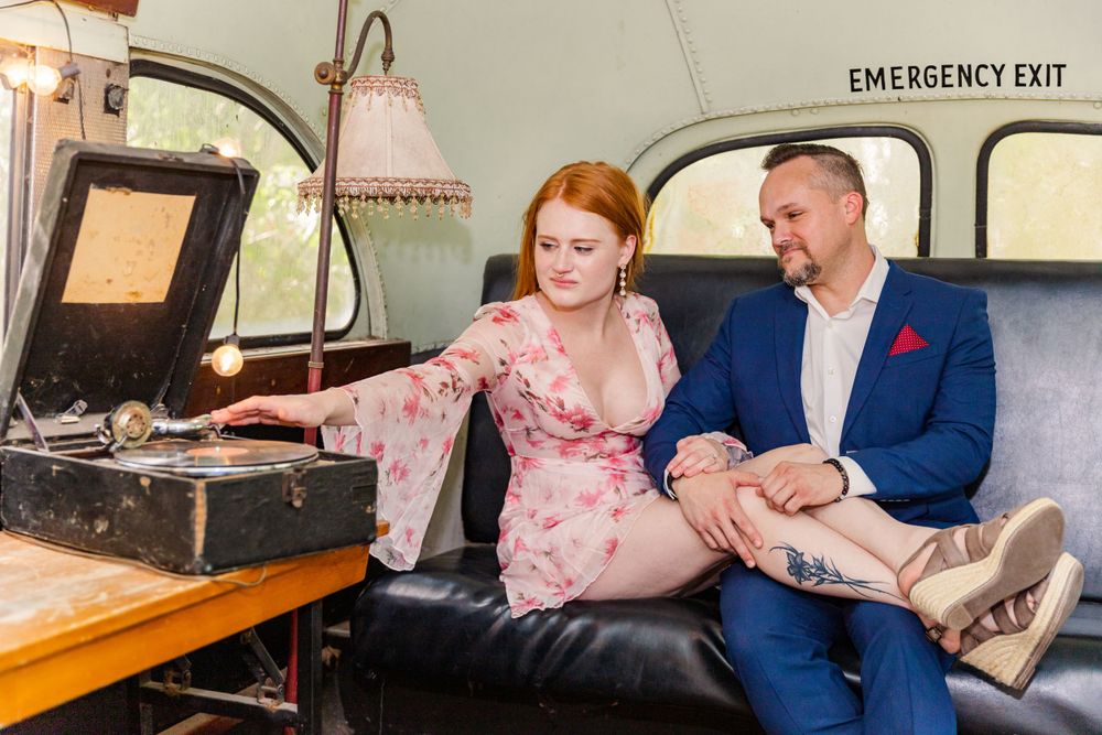 couple in vintage 70s school bus with record player