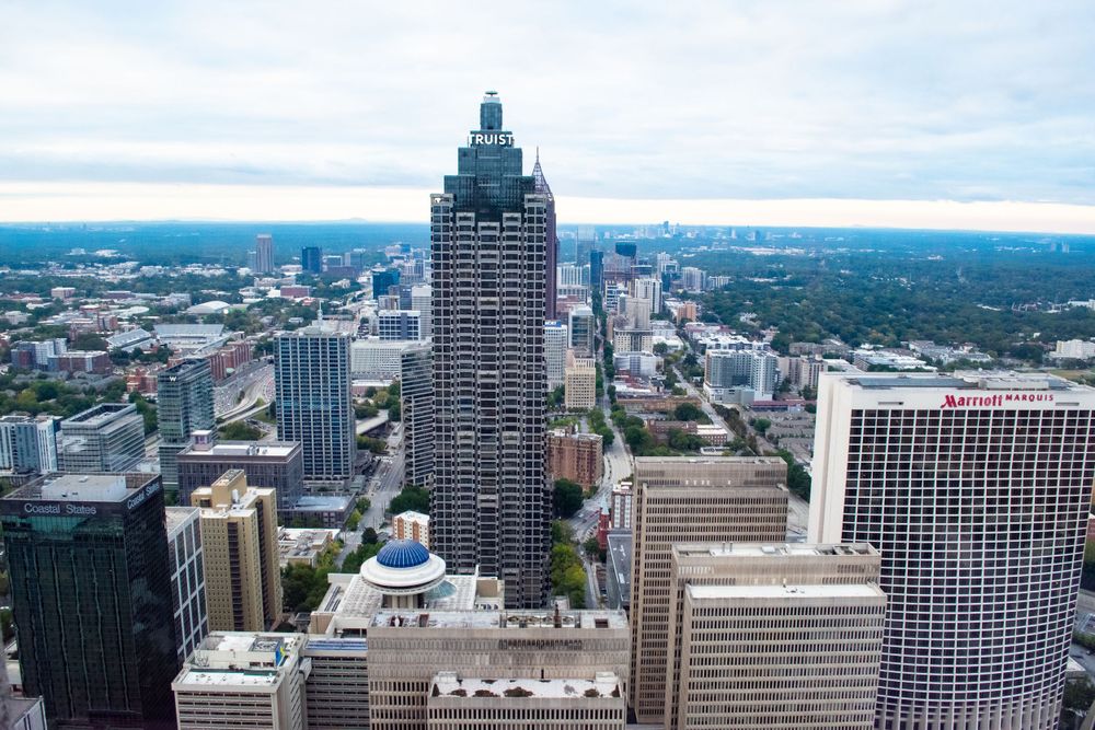 Aerial view of downtown Atlanta skyline featuring iconic skyscrapers against a cloudy sky.