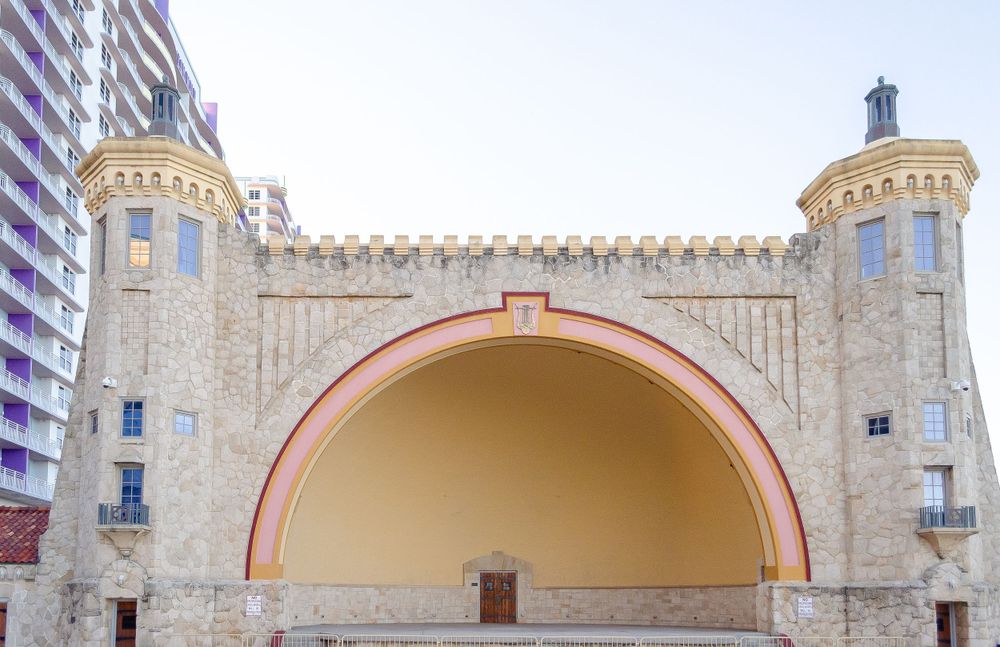 Large stone archway with twin turrets at a beachfront entertainment venue.