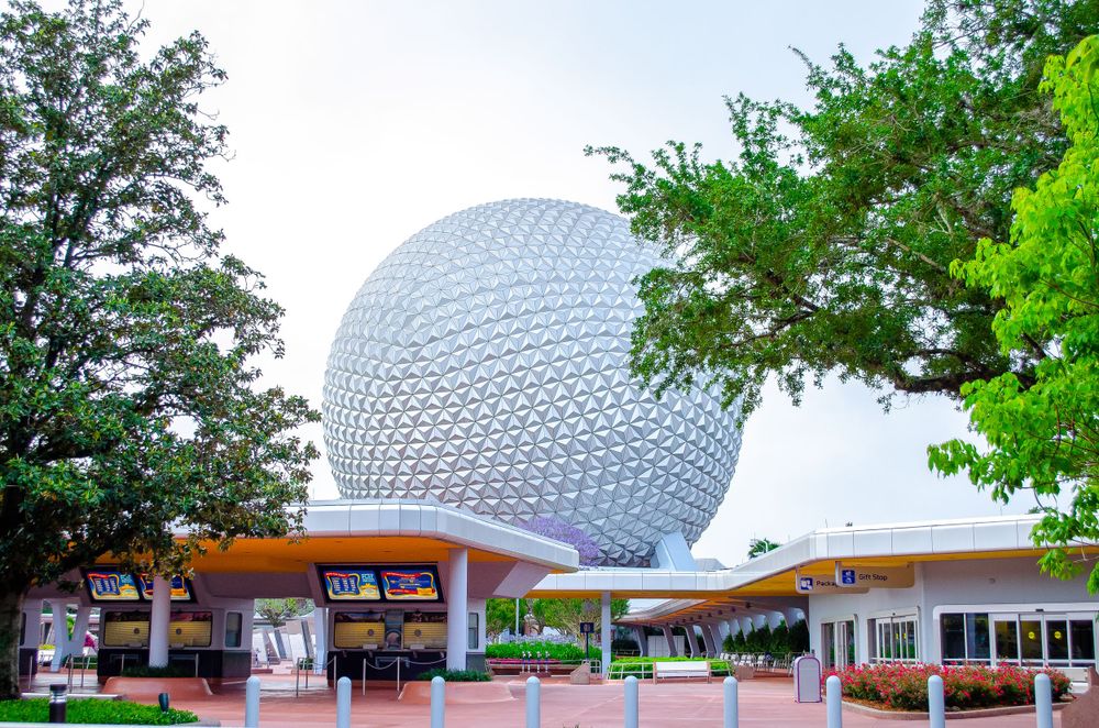 Spaceship Earth, the iconic geodesic sphere at EPCOT theme park, with surrounding buildings and green trees.