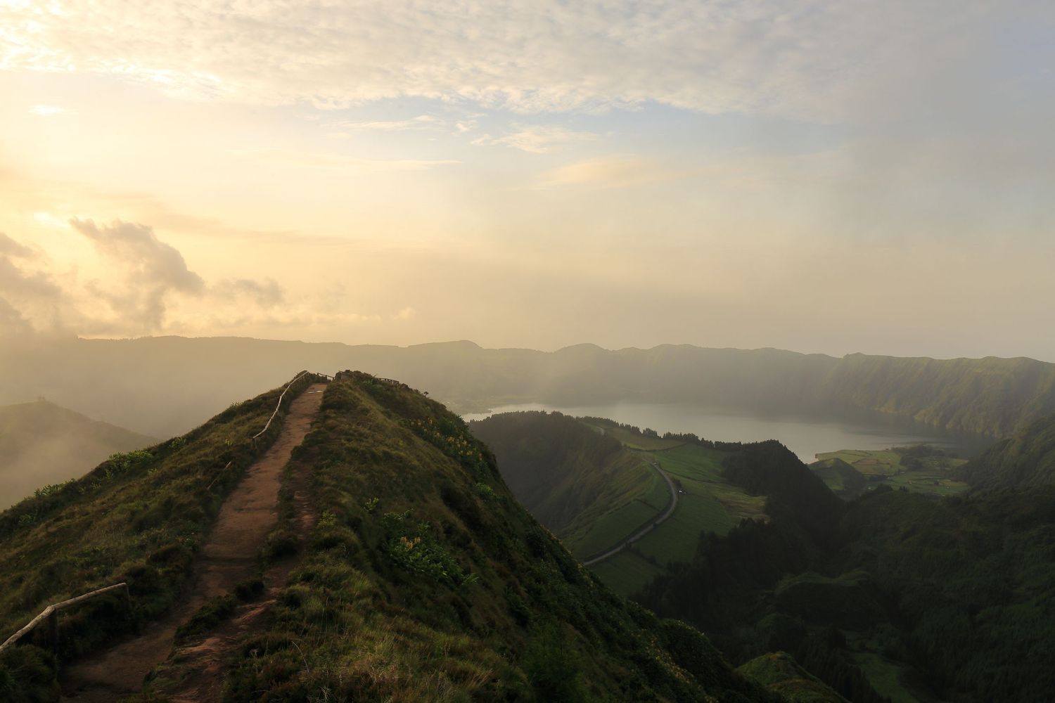 Mountain hiking trail winding along a ridge beneath a golden sunset sky.