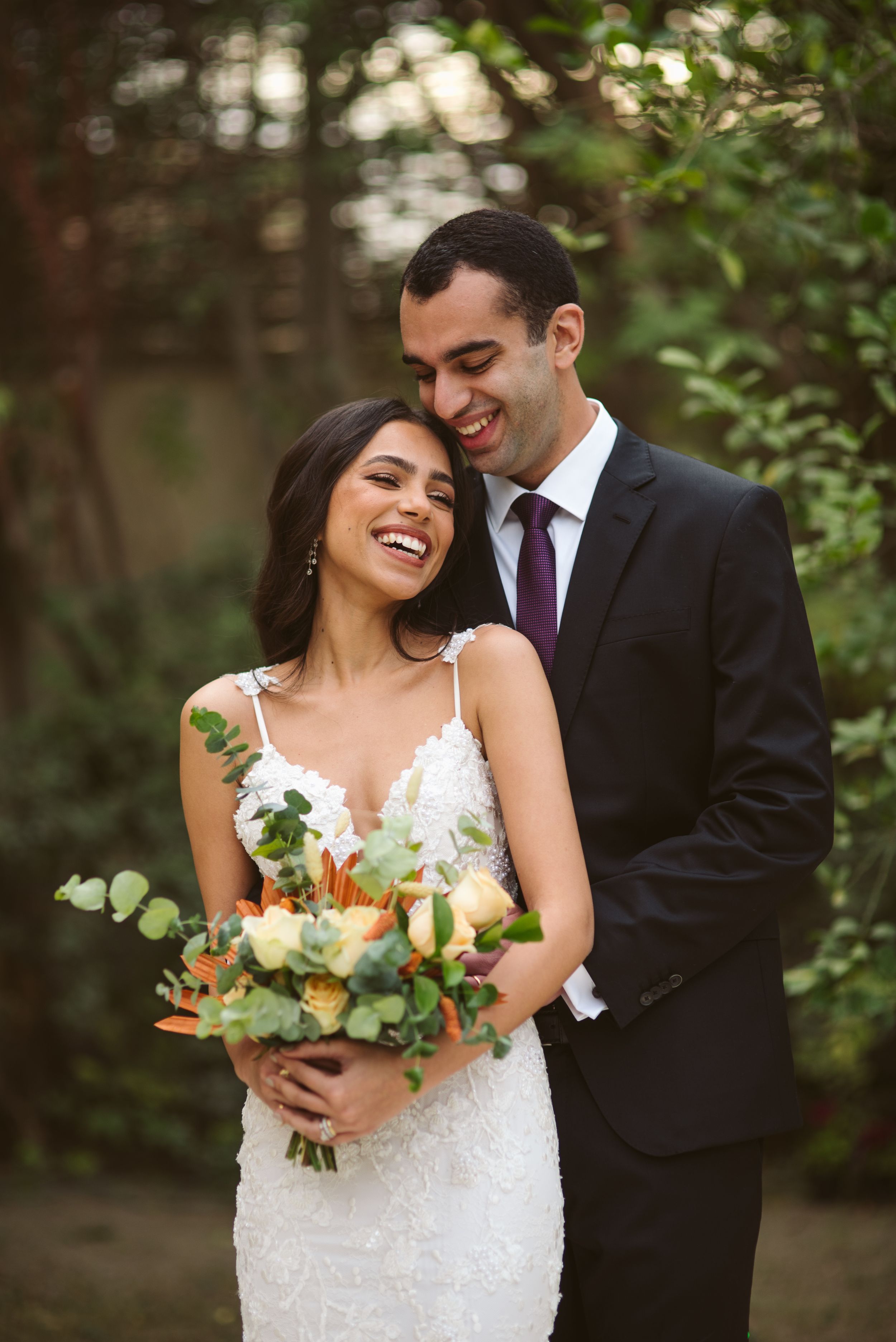 Romantic outdoor wedding portrait with beautiful floral bouquet.