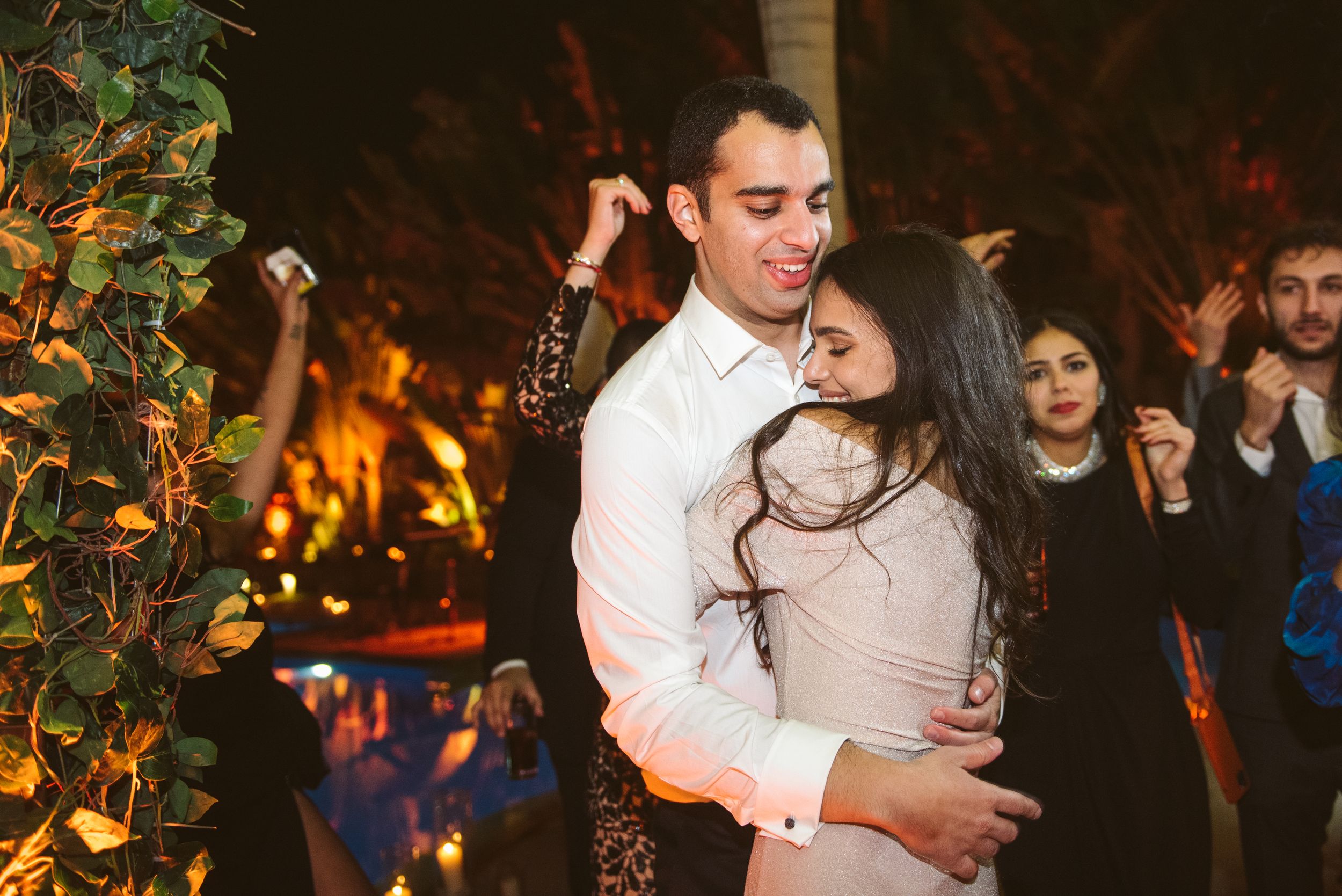 Couple sharing an intimate dance moment at an evening wedding reception with fairy lights.