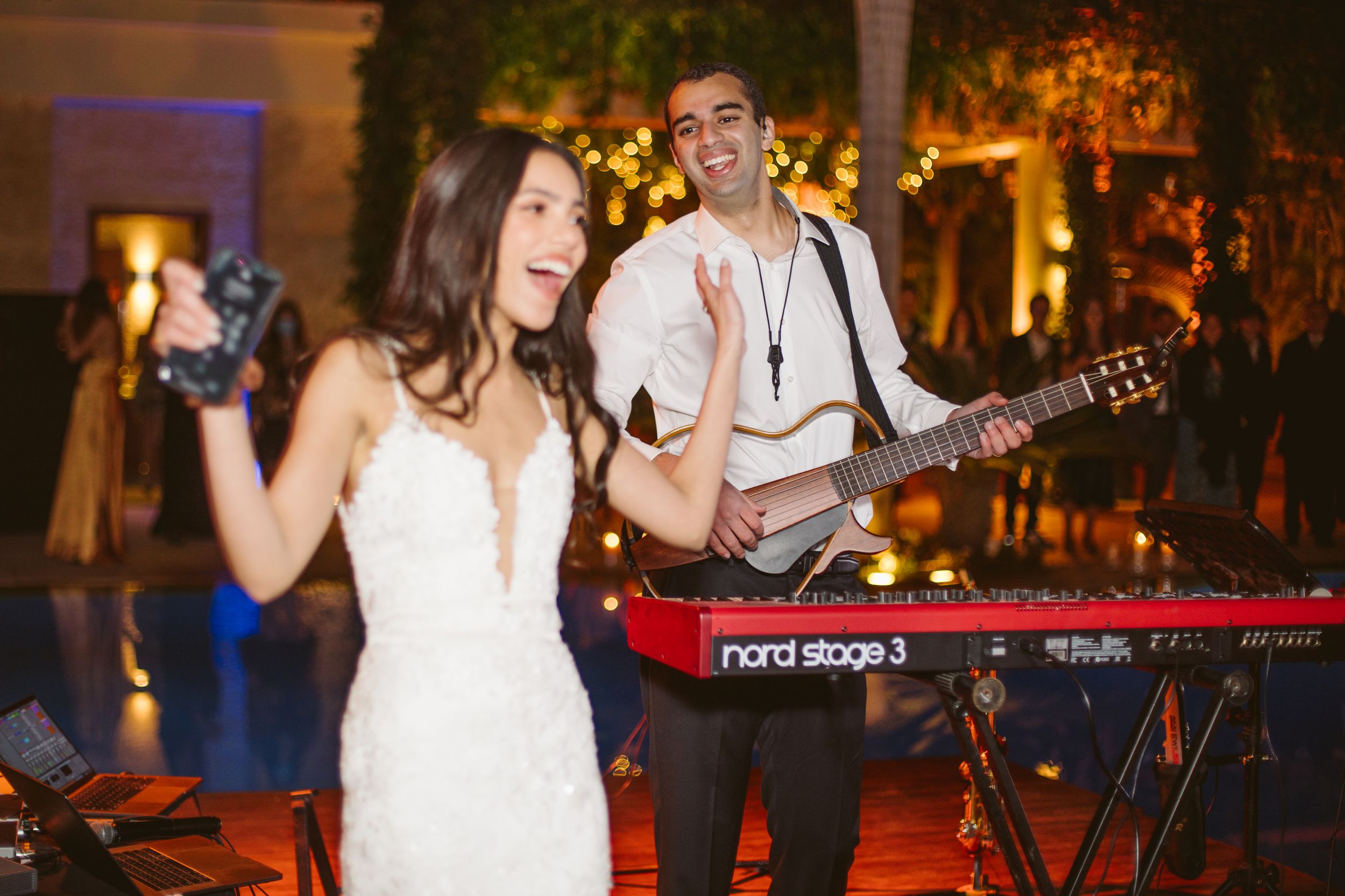 Live band performs while a bride dances at an outdoor evening reception.