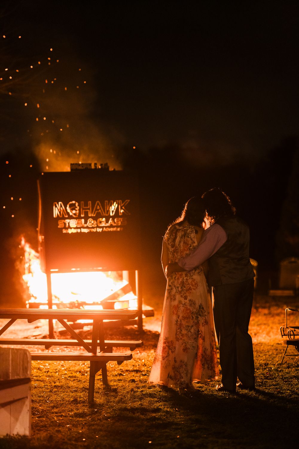 Illuminated fire display at night with text spelled out in flames against a dark background.