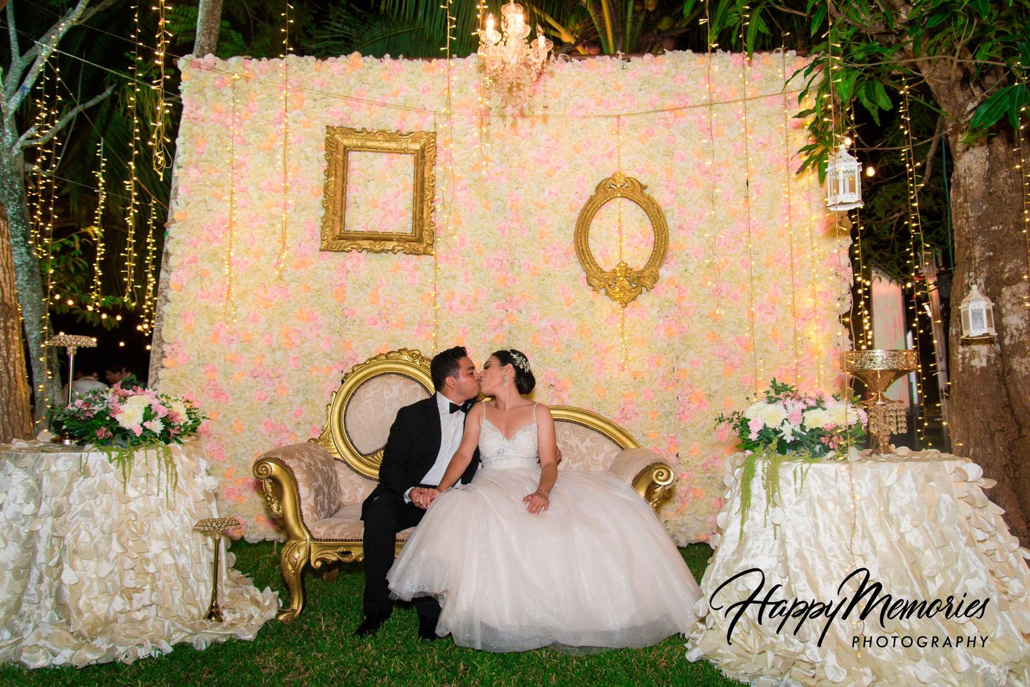 Garden wedding venue decorated with hanging lights and vintage frames.