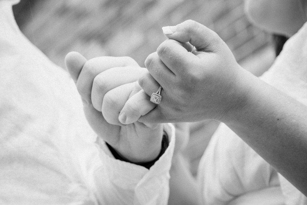 Close up of hands gently touching against white background.