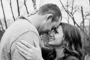 Intimate couple shares tender moments in a natural outdoor setting during fall.
