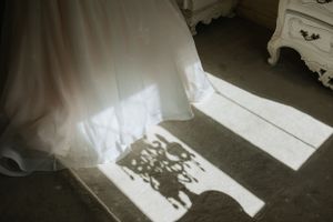 Artistic shadow cast by wedding dress in sunlit room.