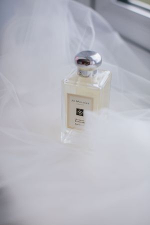 Jo Malone perfume bottle with smoke effect in elegant white setting.