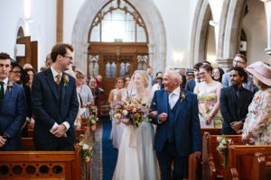 A church wedding ceremony with guests looking on as the couple exchanges vows.