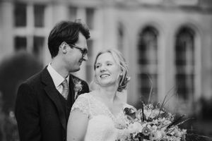 Black and white portrait of newlyweds sharing an intimate moment with bouquet.