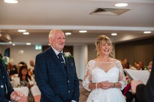 Wedding celebration capturing joyful moments in an indoor reception venue.