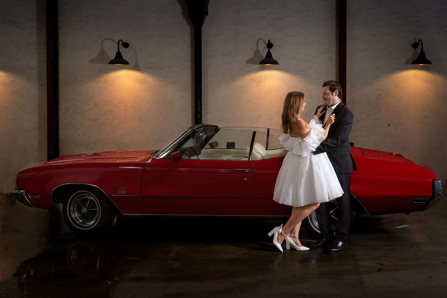 The Historic Pearl parking garage portrait of engaged couple standing infant of classic red convertible