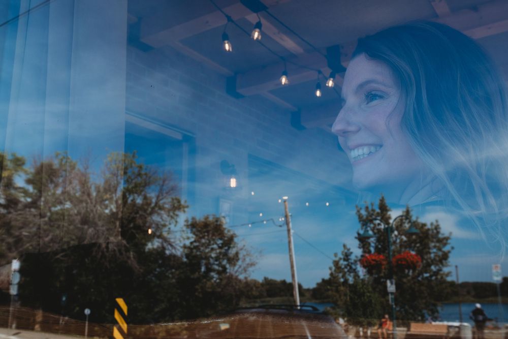 femme qui regarde dehors derrière une vitrine