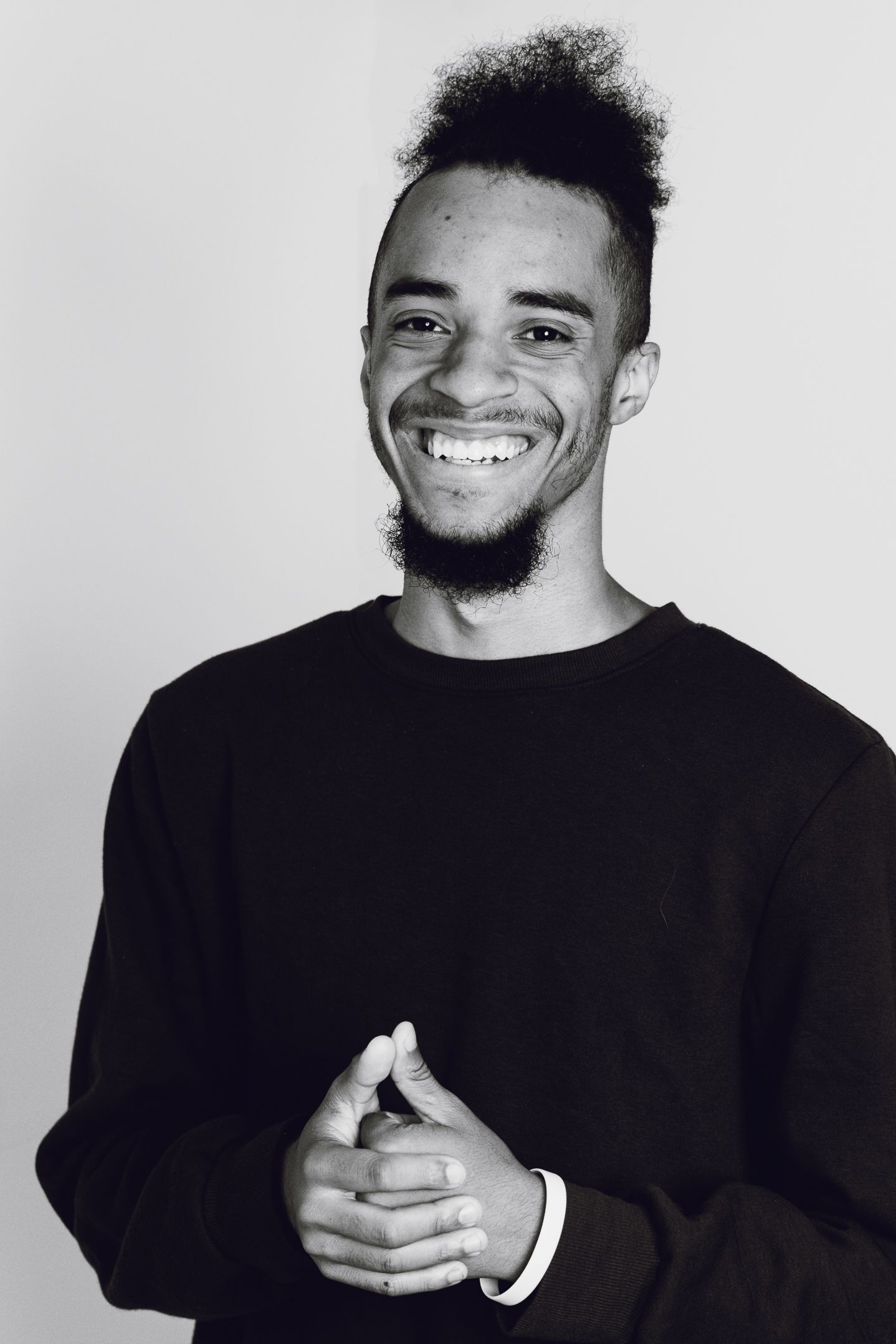 Black and white portrait of a person in a black sweater with natural hair.