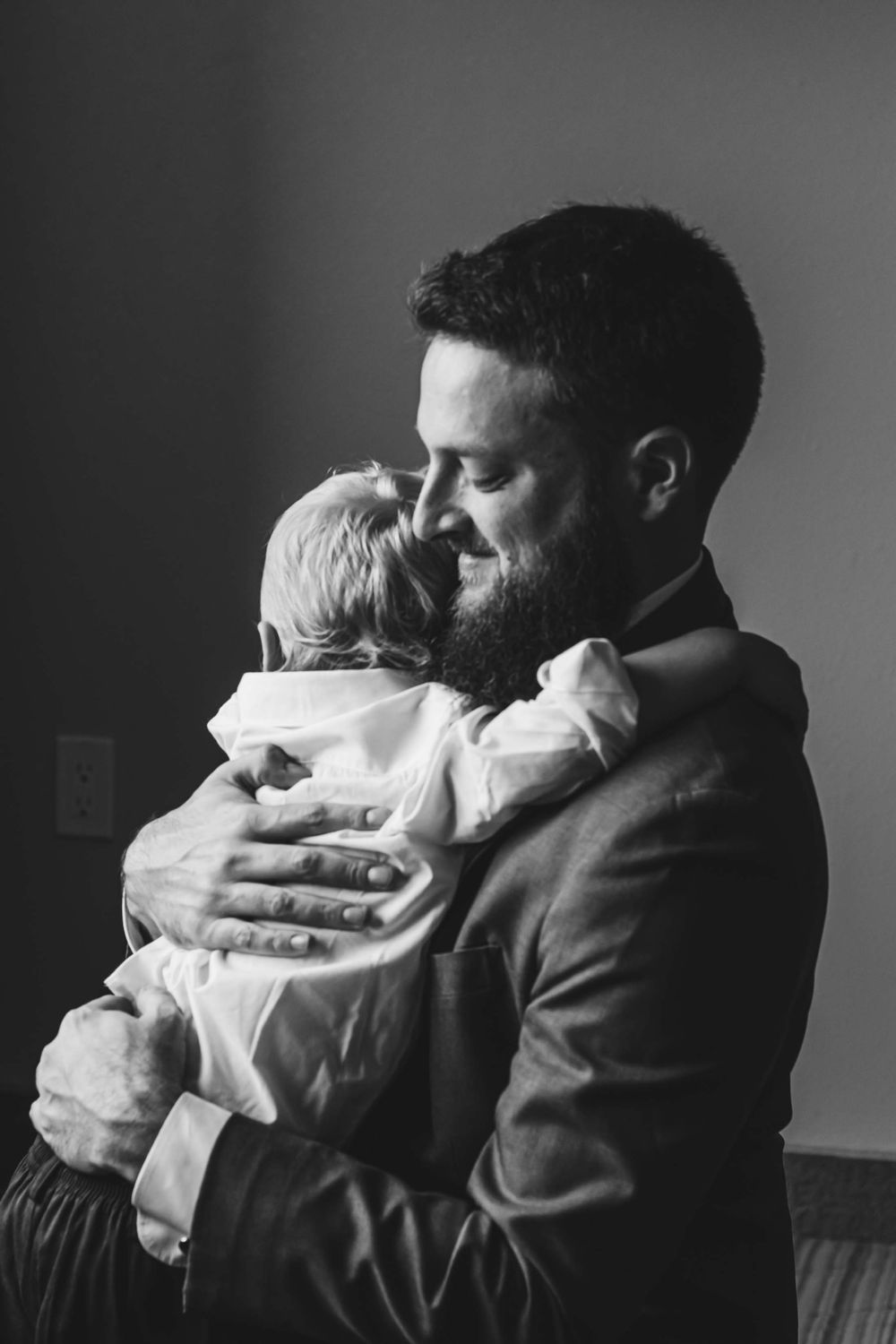 A tender black and white photograph showing a loving embrace between parent and child.