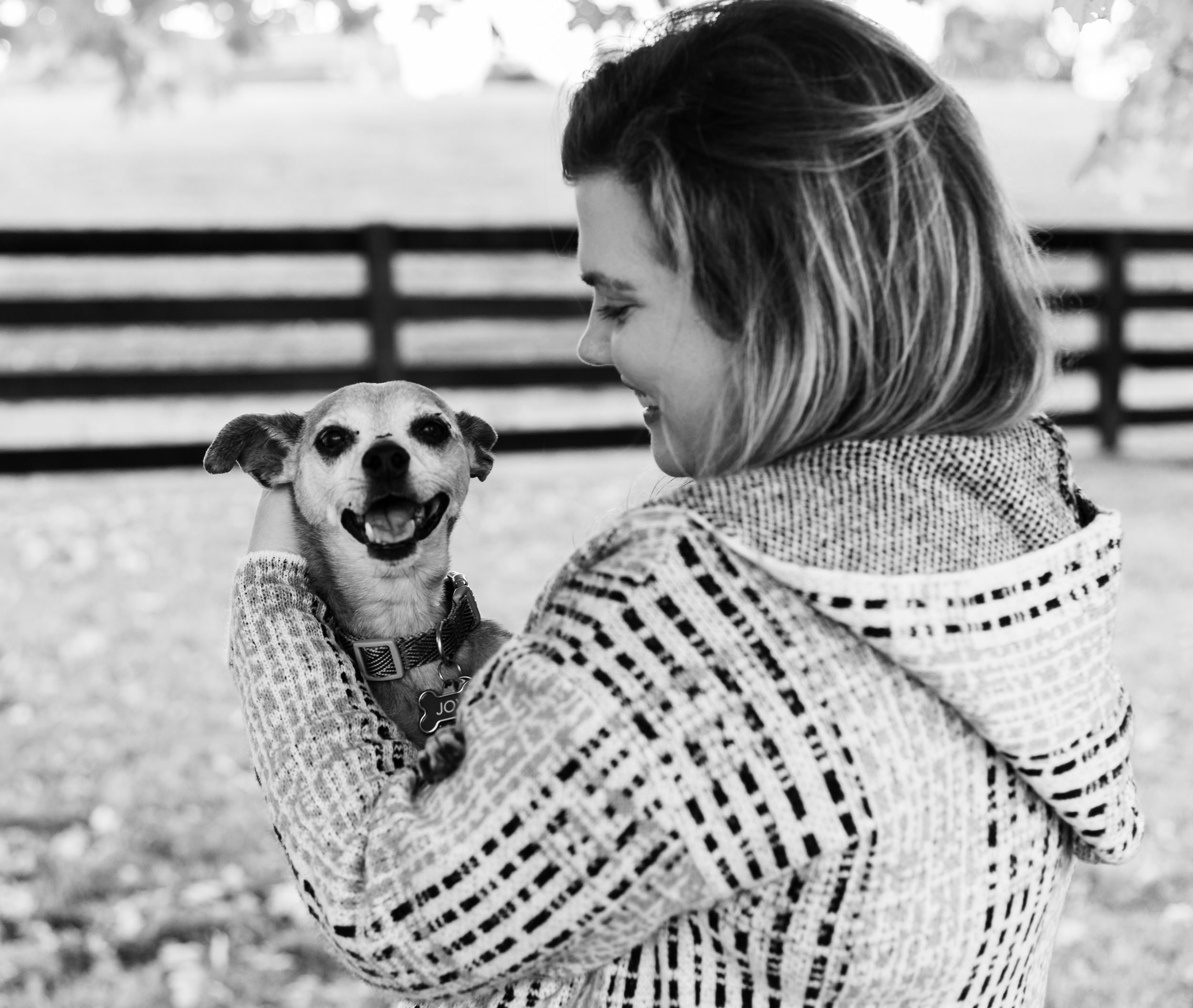 young adult cradling her dog, dog is smiling