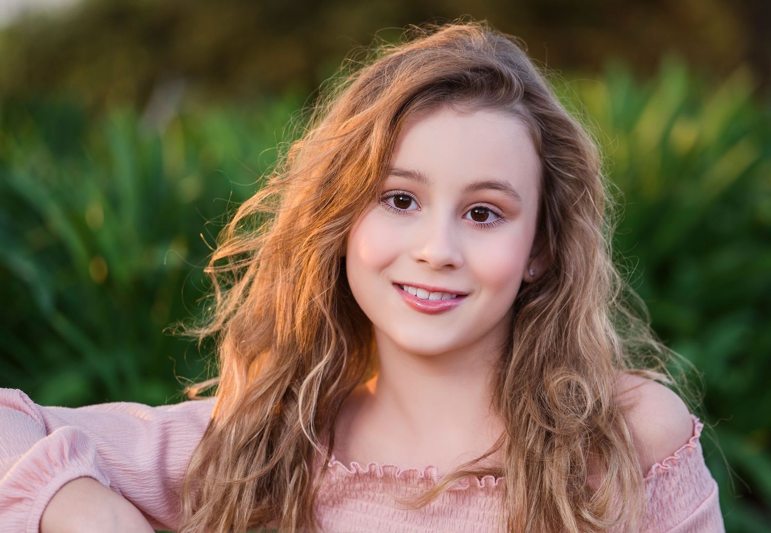 Natural light portrait with soft sunset glow and pink clothing.