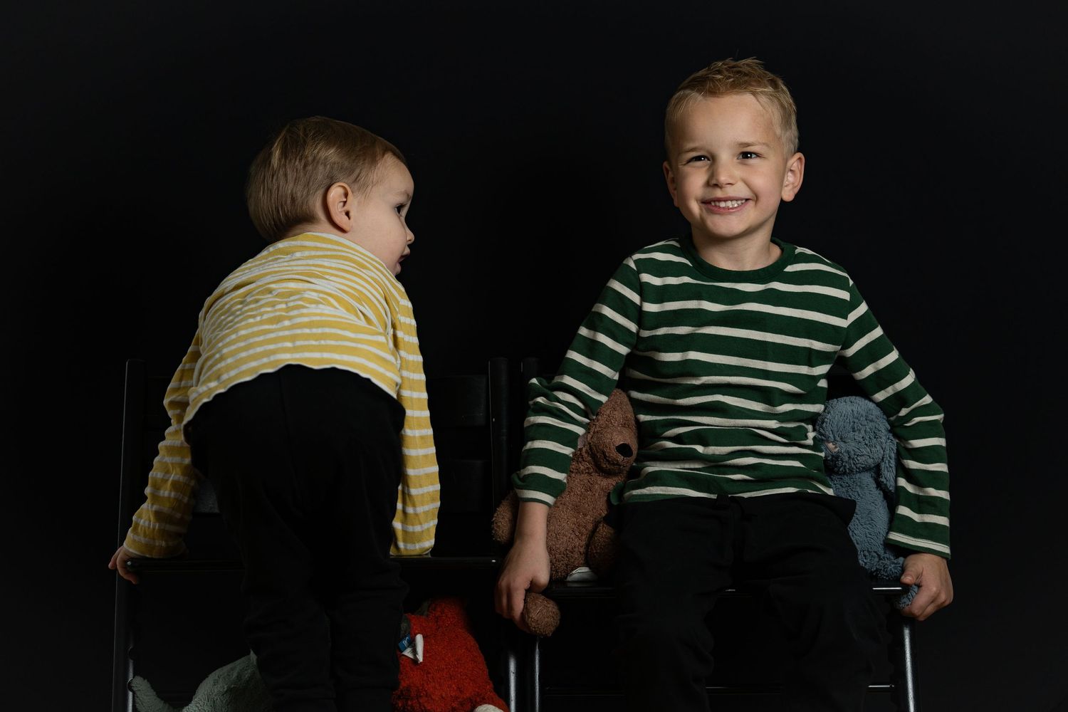 Søskendeportræt med ægte smil og leg – to brødre i et naturligt øjeblik fyldt med personlighed, humor og charme i studiet.