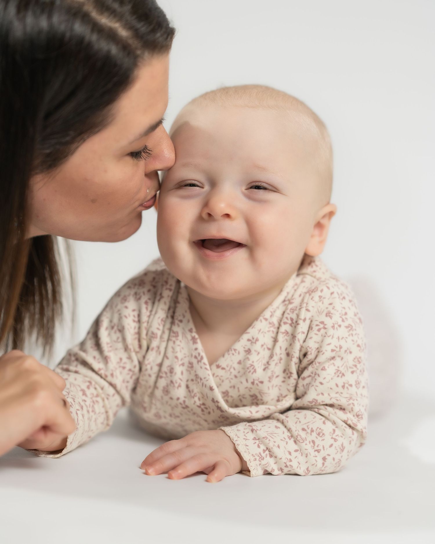 Familie- og babyfotografering i Jægerspris – mor giver kys til sin baby under studieportræt. Professionel fotograf i Frederikssund og Nordsj