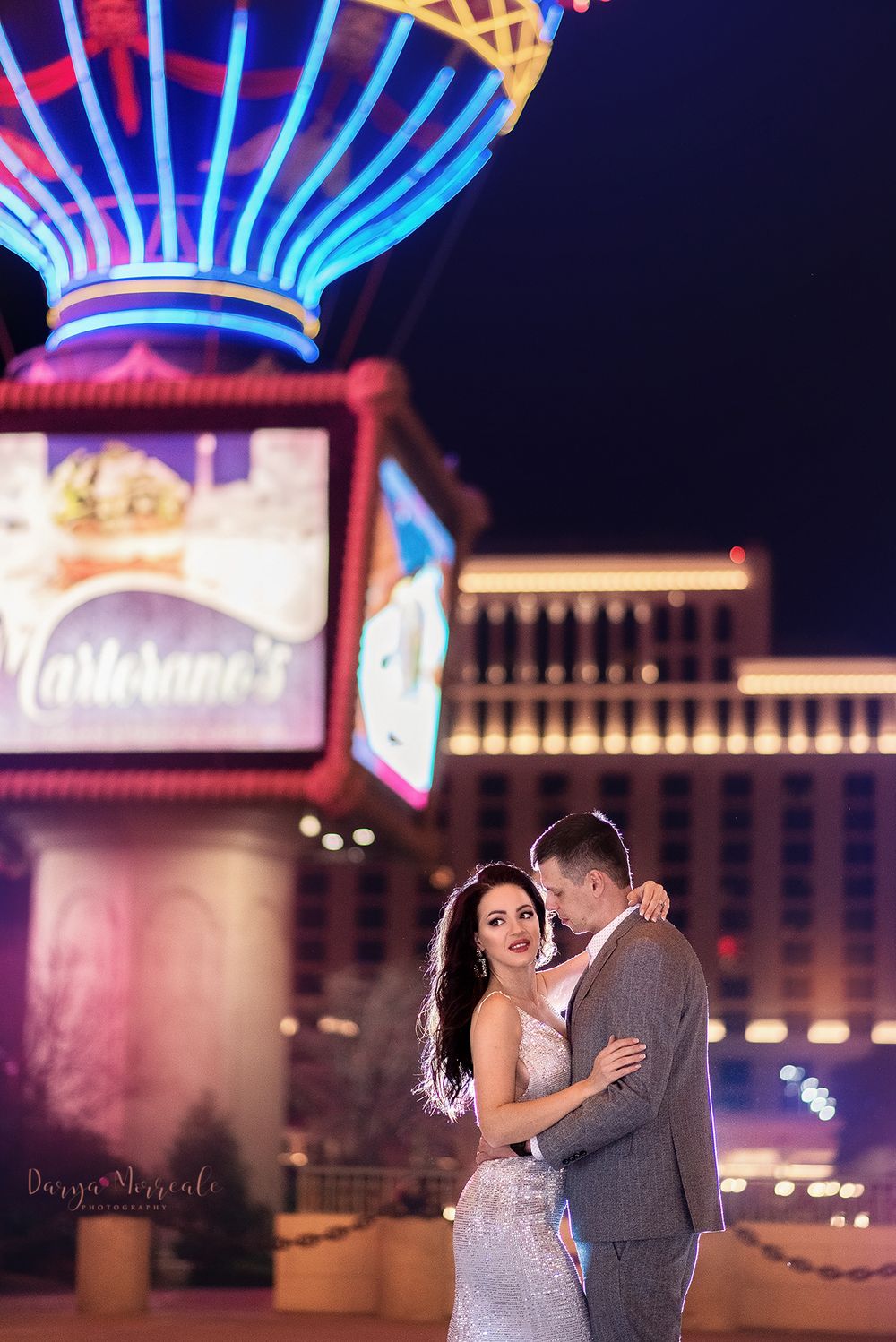 A couple shares a romantic moment under the neon lights of Las Vegas.