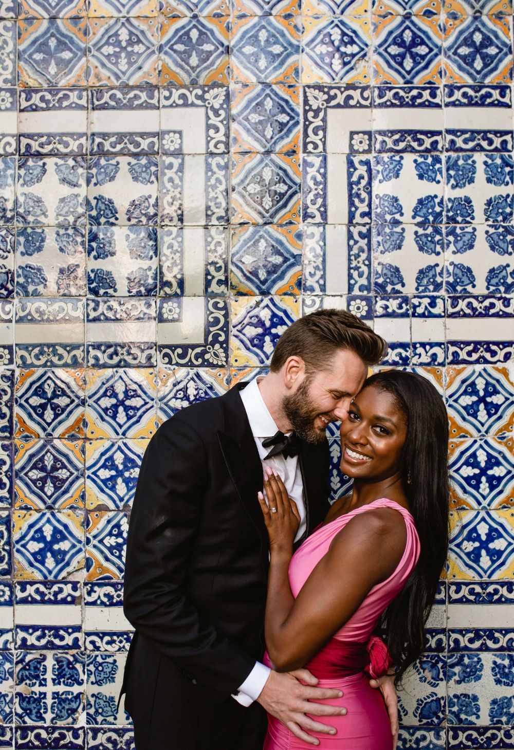 Romantic portraits against a wall of blue and white Portuguese-style decorative tiles.
