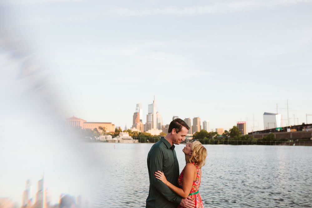 Romantic waterfront scene with city skyline in background during golden hour.