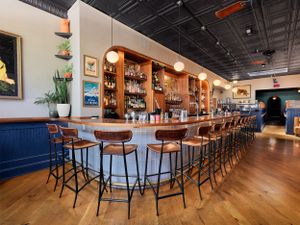 Contemporary restaurant bar area featuring hardwood floors and high-top seating.