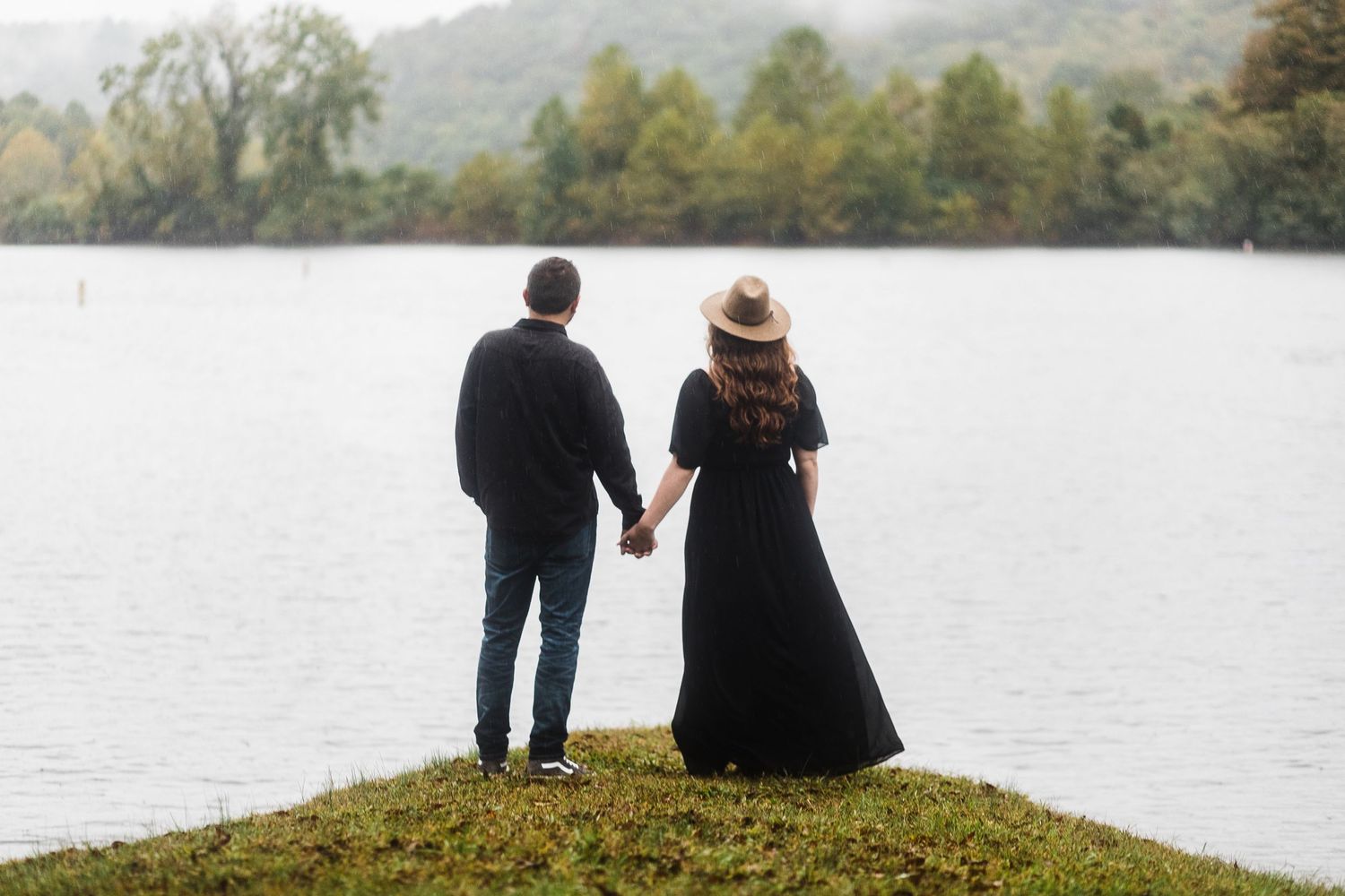 Couple enjoying a peaceful moment by the lake with mountains in the distance.