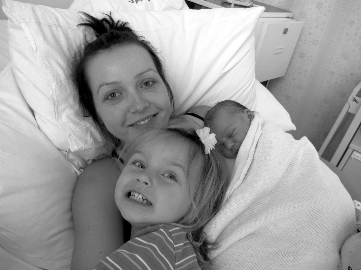 A heartwarming black and white hospital photograph showing tender family moments.