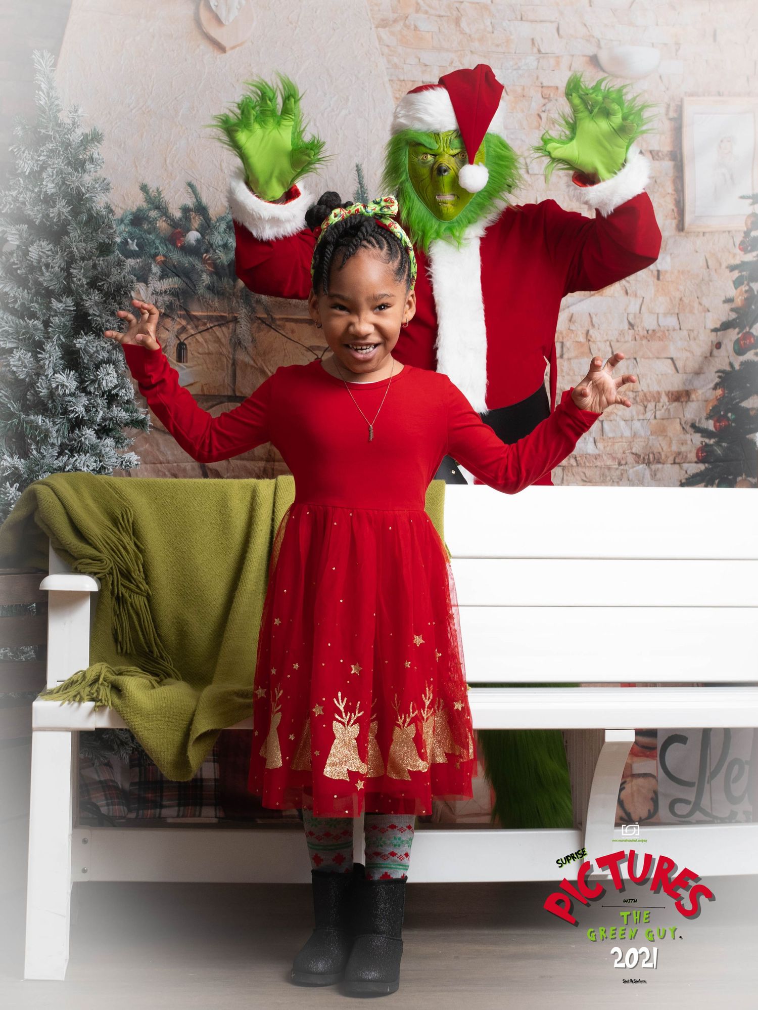 A festive holiday photo scene with red dress, Grinch costume, green blanket and Christmas decorations.
