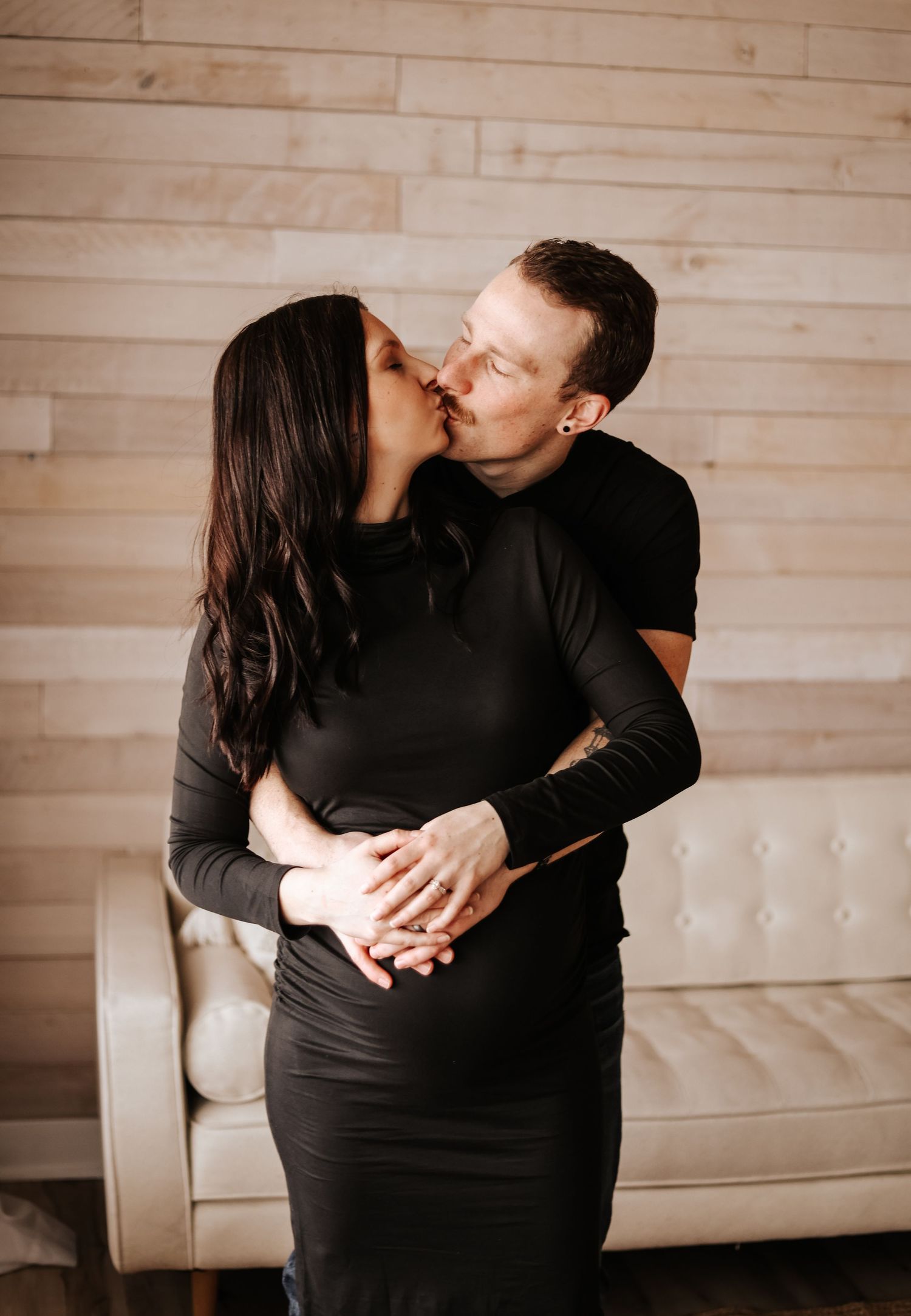 Intimate couple sharing tender moment during maternity photoshoot.
