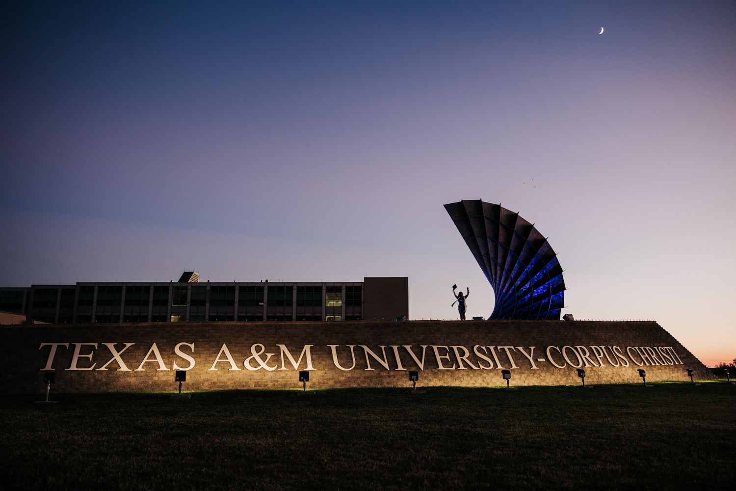 college senior girl silhouette with moon on top of texas A&M university corpus christi sign