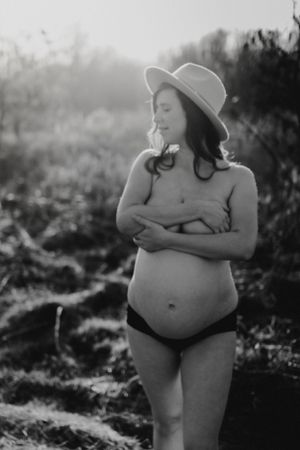 Intimate black and white maternity photos captured in natural outdoor setting.