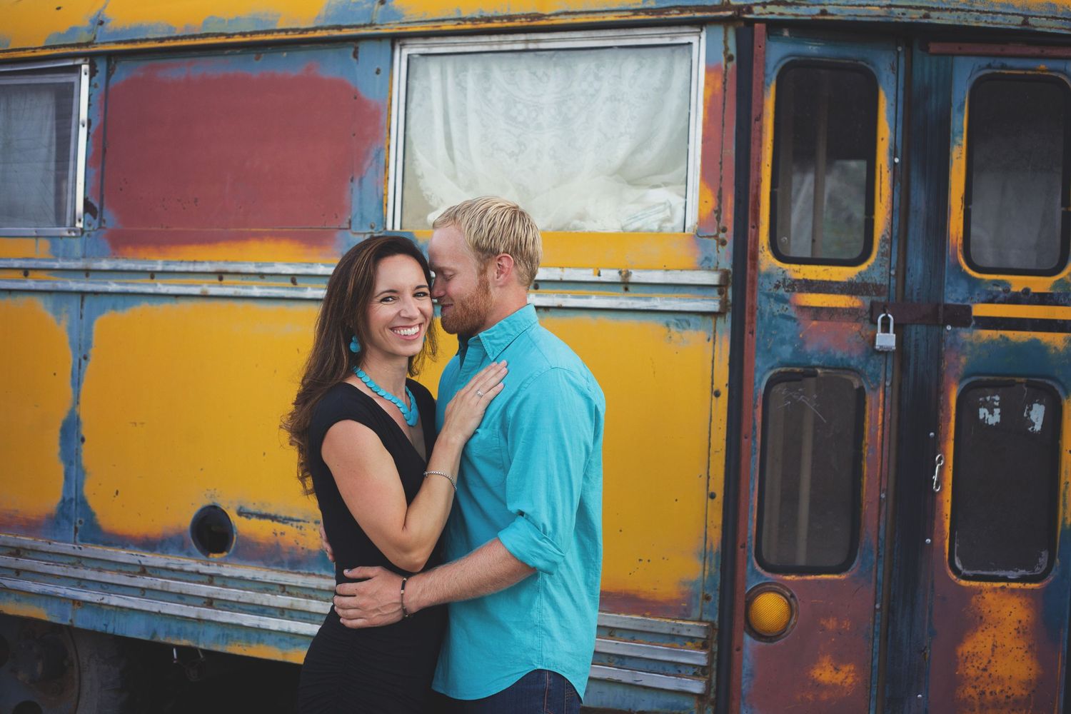A romantic moment captured against a colorful vintage bus background.