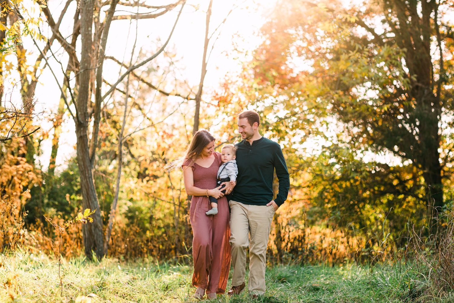 Romantic couple embraces in a sun-drenched autumn meadow during golden hour.