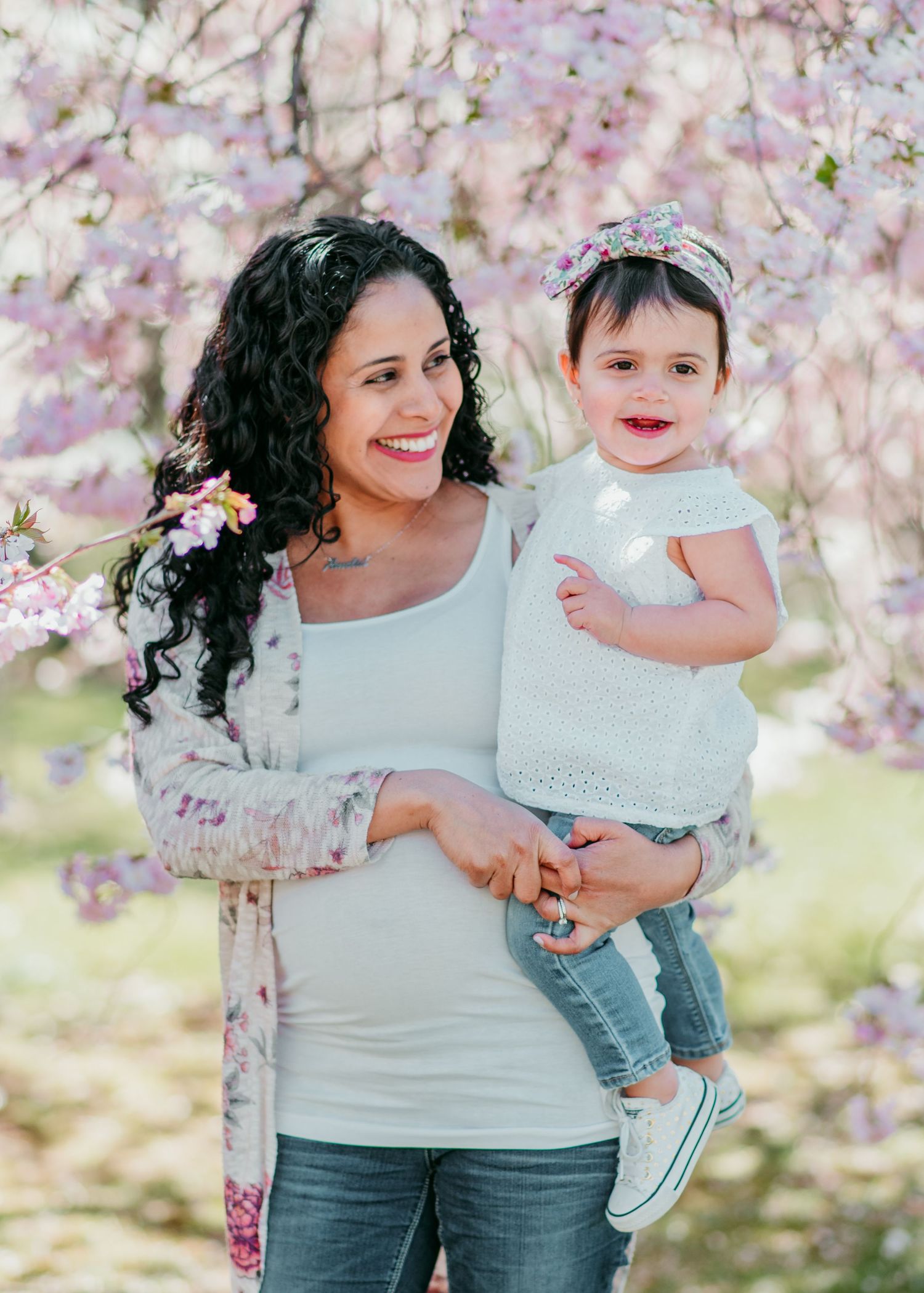 Sweet springtime portrait with mother and child surrounded by blooming cherry blossom trees in the background in Belleville.