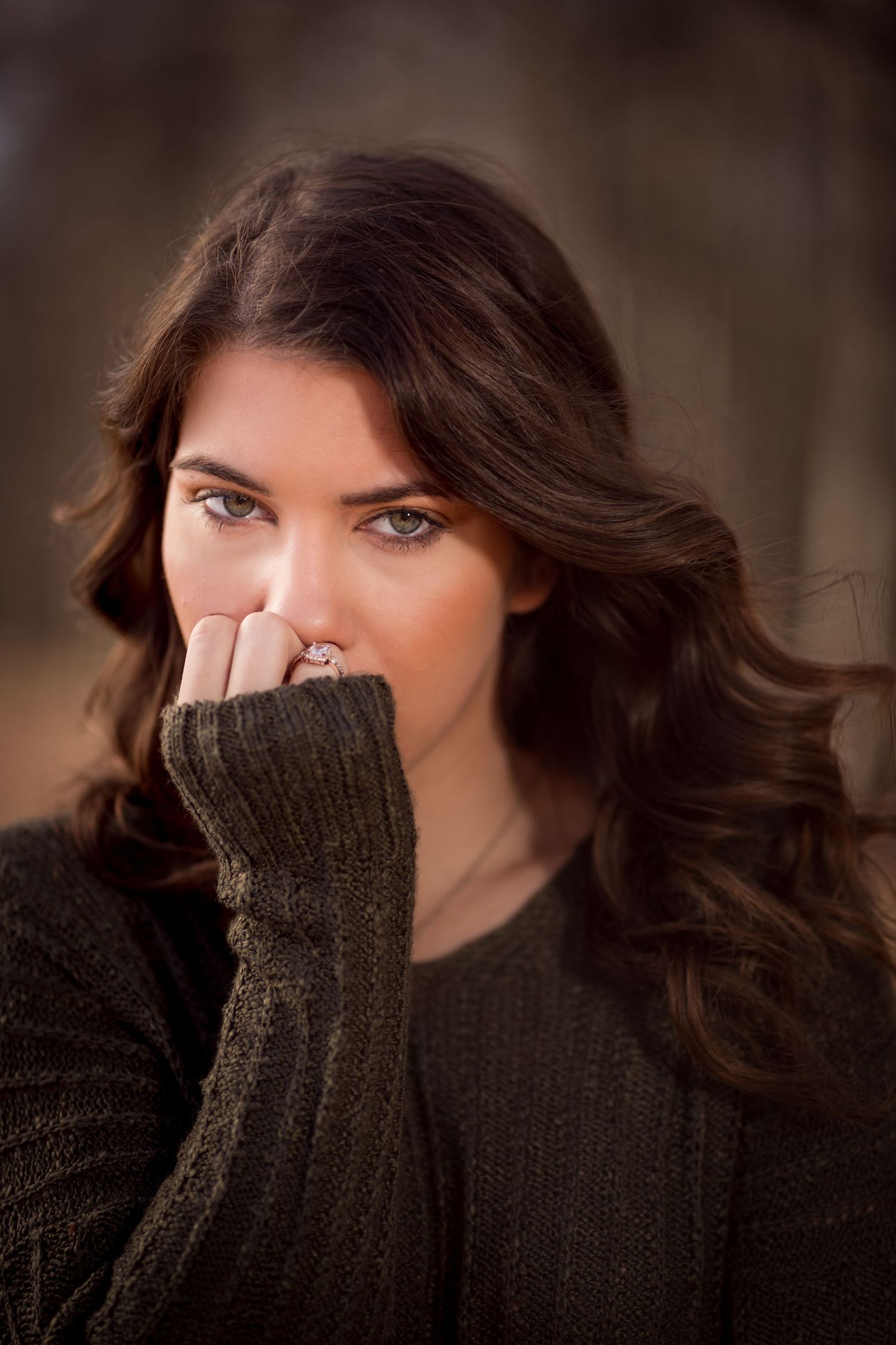 Dramatic close-up shots featuring a dark knit sweater against a blurred brown background.