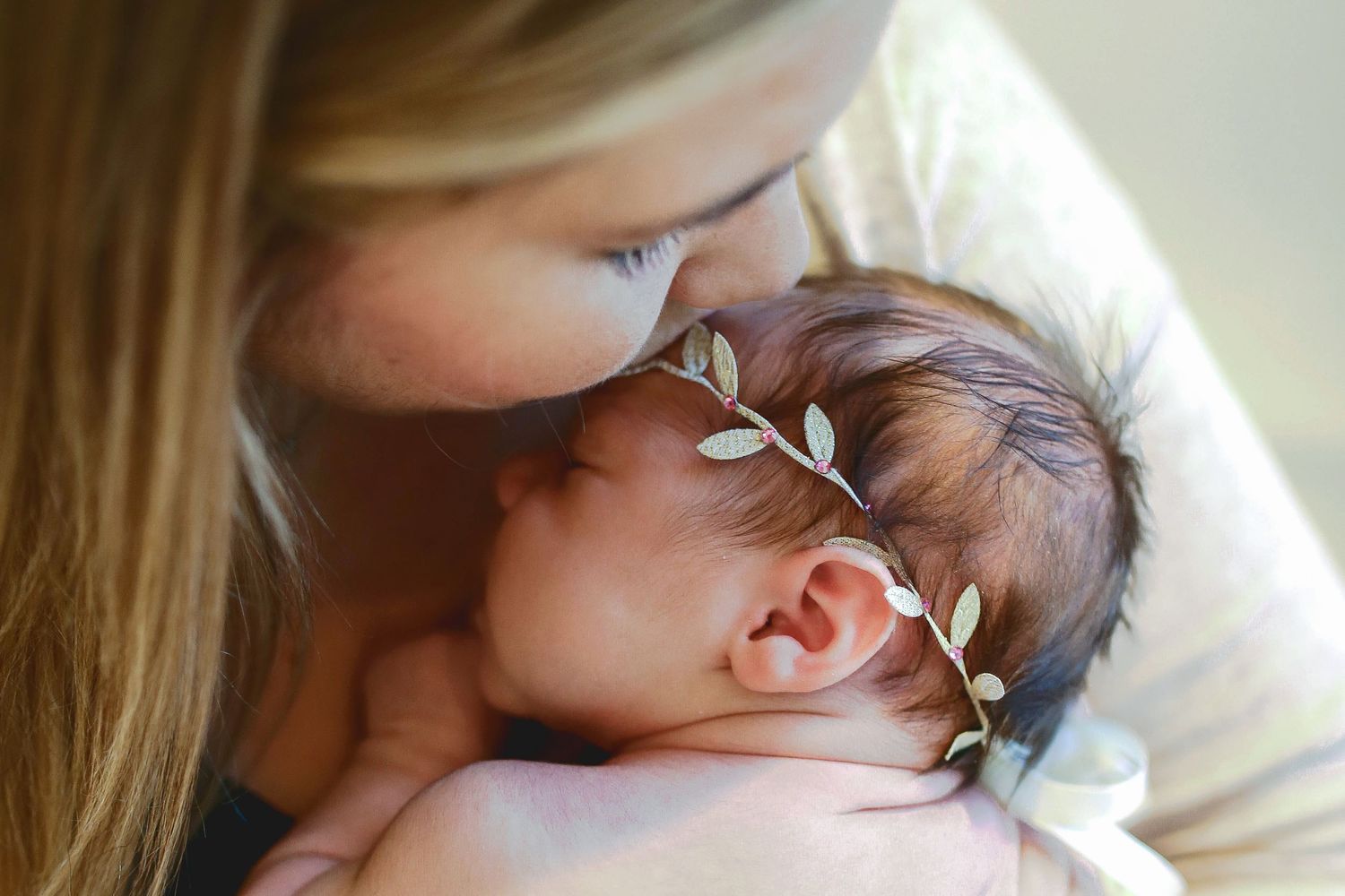 momma kissing her newborns head with ivy leaf headband